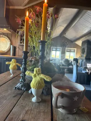 a wooden table with two candles and a cup of coffee at Fjellhytte med boblebad og utsikt på Blefjell in Flesberg