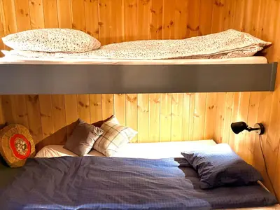 a bedroom with two bunk beds and a bed at Elegant 2 bedroom ski in, ski out apartment next to Fyri Resort in Hemsedal in Hemsedal