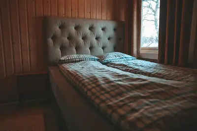 a bed with a plaid blanket and a window at Close to cross-country skiing, slalom slope and mountains - Soltun Geilo in Hol