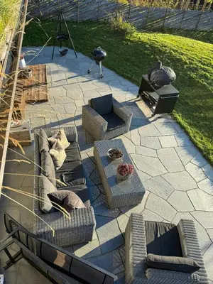 a patio with couches and chairs and a tv at Timber Cabin With Hot Tub In Gjevilvassdalen in Oppdal