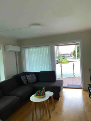 a living room with a black couch and a table at City apartment with balcony and 3 bedrooms! in Bergen