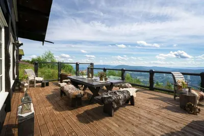a wooden deck with a table and chairs on a balcony at Large Cabin For 20 By Norefjell Ski Resort in Noresund