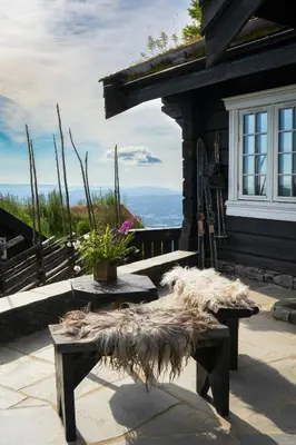 a porch of a house with two benches and a window at Fjellhytte Med Panorama På Toppen Av Norefjell in Noresund
