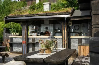 an outdoor kitchen with a table and a stone oven at Fjellhytte Med Panorama På Toppen Av Norefjell in Noresund