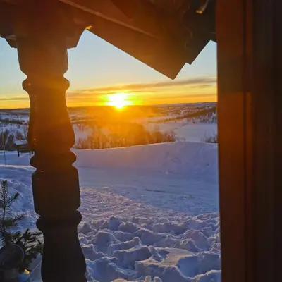 a view from a window of a winter sunset at Leilighet på fjellet nær Geilo in Hol