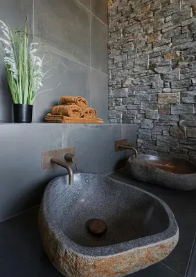 a bathroom with two sinks and a stone wall at Designer Cabin For 16 With Spa In Turufjell in Flå