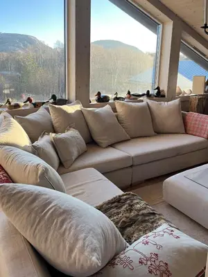 a large couch in a room with a large window at Cottage With Sunny Terraces And Sea Views in Lysøysund