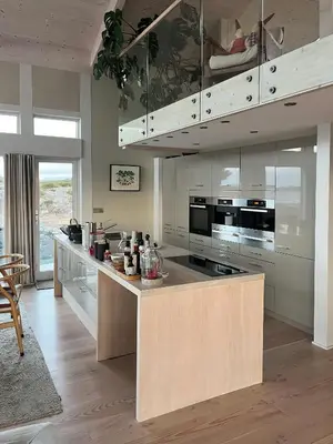 a kitchen with a island with a stove top oven at Cottage With Sunny Terraces And Sea Views in Lysøysund