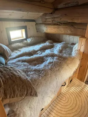 a large bed in a cabin with a comforter at Sits in the middle of Reinheimen and Dovrefjell Rondane in Dombås