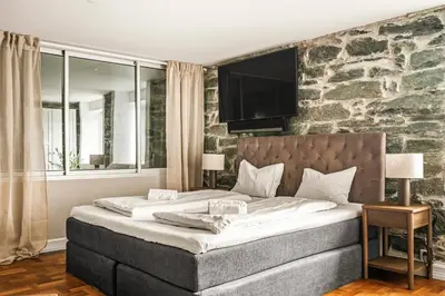 a bedroom with a large bed with a stone wall at A Dream Home with Spectacular Views - NEW! in Bergen