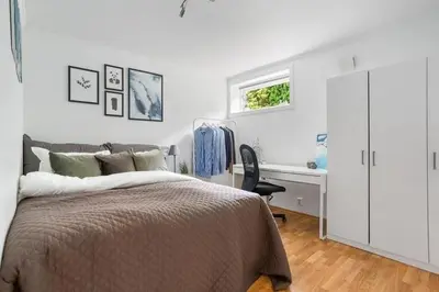a bedroom with a bed and a desk and a window at Central 4 room apartment in Bergen