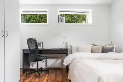 a bedroom with a desk and a chair next to a bed at Central 4 room apartment in Bergen