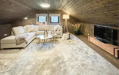 a living room with a couch and a tv at Lovely Home In Sjusjøen With Sauna in Sjusjøen
