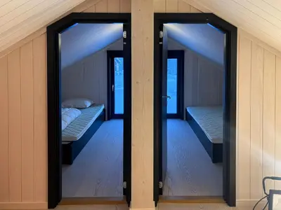 two beds in a room with two windows at Architect Cabin With Ski-In Near Trysil in Trysil