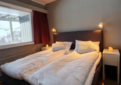 two twin beds in a bedroom with a window at Kvikne Fjellhotell & Kafé in Tynset