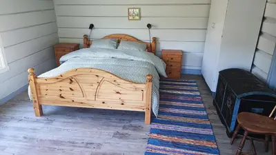 a bedroom with a wooden bed in a room at The old farm Lodge Lykkeslet