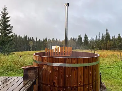 a wooden barrel with a hot tub in a field at Log Cabin With 360-Degree Views Near Trysil in Trysil