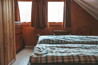 a bedroom with two beds and a dresser and two windows at Solyun in Hol