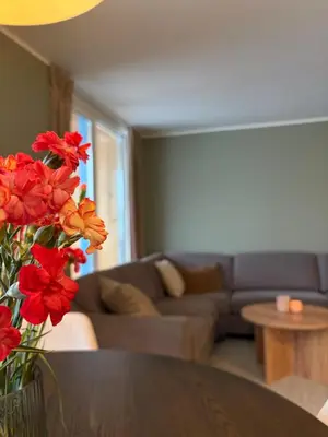 a living room with a couch and a table with red flowers at Modern apartment in Raufoss in Raufoss