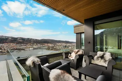 a balcony with chairs and a view of a city at Bellevue Penthouse - Exclusive Design in Bergen