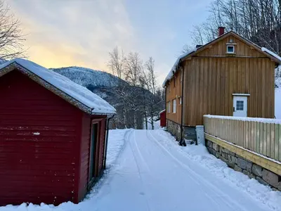 a red barn and a building in the snow at Pellan in Surnadal