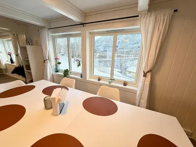a dining room with a table and a window at Pellan in Surnadal