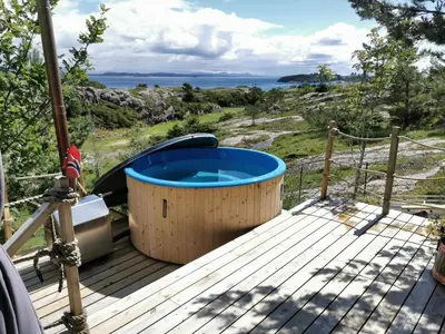 a hot tub on the deck of a house at Cozy family cottage with a view