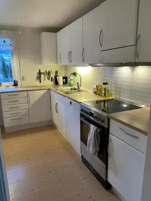 a kitchen with white cabinets and a sink at Bolig på Kaupanger in Kaupanger