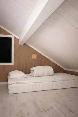 a white bed in a room with a ceiling at Modern family cabin with ski in out, central location in Beitostølen in Beitostøl