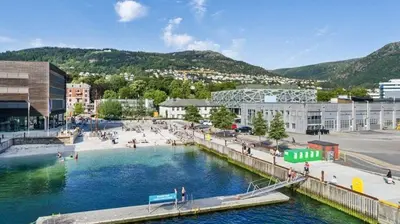 a large pool of water in a city with buildings at Beautiful apartment in the heart of Bergen in Bergen