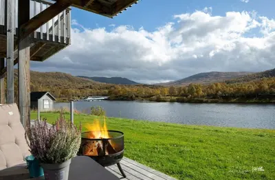 a fire pit sitting on a table next to a lake at New! Stay close to Hardangervidda & Vøringsfossen in Eidfjord