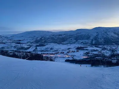 a view of a snowy mountain with a town in the distance at New! Stay close to Hardangervidda & Vøringsfossen in Eidfjord