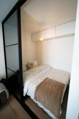 a bedroom with a bed and a large mirror at Ultra central flat with balcony in Bergen