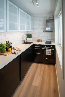 a kitchen with black cabinets and a sink at Ultra central flat with balcony in Bergen