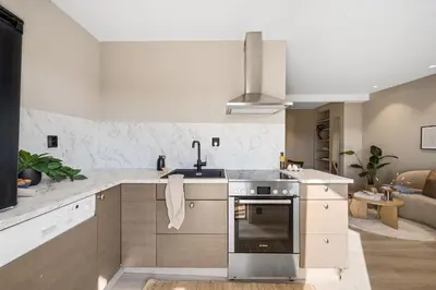 a kitchen with a sink and a stove top oven at Toppleilighet på Sandviken med balkong in Bergen