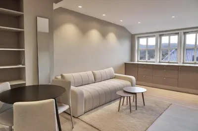 a living room with a couch and a table at Toppleilighet på Sandviken med balkong in Bergen