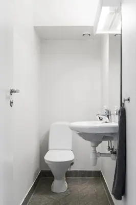 a bathroom with a white toilet and a sink at Central 4 room apartment in Bergen