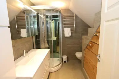 a bathroom with a sink and a shower and a toilet at Alnes Gård in Ålesund