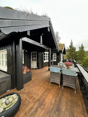 a deck with chairs and a table on a house at Cosy cabin in Eggedal