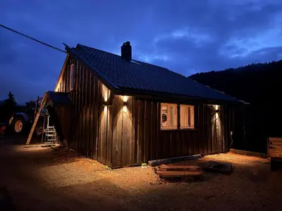 a small cabin with lights on the side of it at Quiet detached house in Haukeli, modern and homey in Haukeligrend