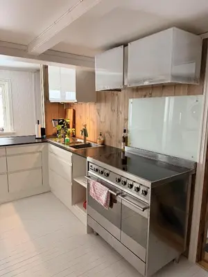 a kitchen with stainless steel appliances and white cabinets at Quiet detached house in Haukeli, modern and homey in Haukeligrend