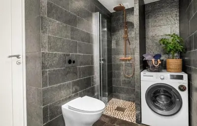 a bathroom with a toilet and a washing machine at House 2 rooms in Trondheim