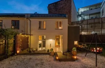 a large white house with lights in front of it at House 2 rooms in Trondheim