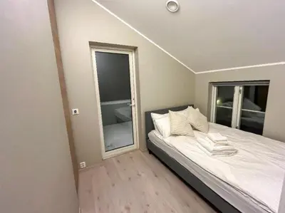 a bedroom with a bed and a large window at House 2 rooms in Trondheim