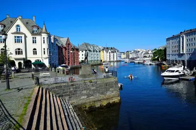 a river with boats in a city with buildings at Great apartment in the center of Ålesund in Ålesund