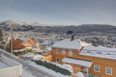 a city with snow on the roofs of buildings at Central apartment with parking in unique surroundings in Bergen