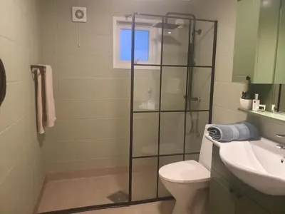 a bathroom with a shower and a toilet and a sink at Central apartment with parking in unique surroundings in Bergen