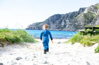 a person walking on a beach with the ocean at Large house with Ocean view at Ervik and Vestkapp