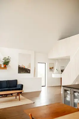 a living room with white walls and a blue couch at Large house with Ocean view at Ervik and Vestkapp