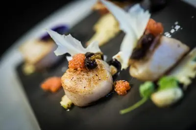 a black plate with some food on it at Hjorten Hotell Hitra in Fillan